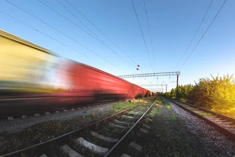 Freight train in motion with blur effect at sunset. Cargo transportation by r Stock Photos