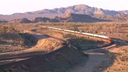 A Freight Train Moves Across The Desert From A High Angle. Stock Footage
