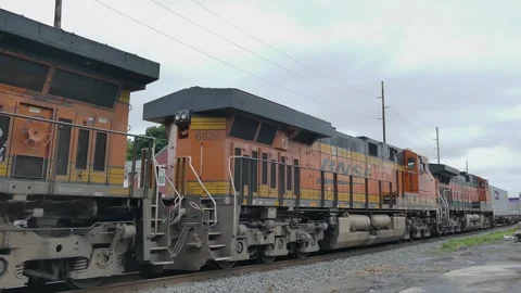 A freight train moves along the tracks in a small town. Cargo containers are Stock Footage 340406004