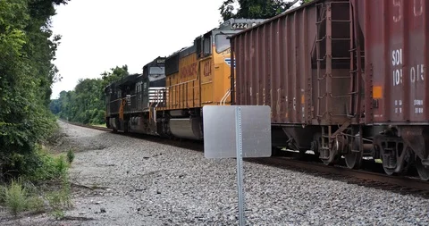 Freight train moves right to left after passing through railroad crossing. Stock Footage 117935071