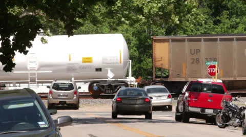 Freight train moves slowly through old town spring Stock Footage 24650306
