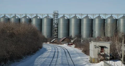 A freight train is moving against the background of huge grain storage elevator Stock-Footage 236453463