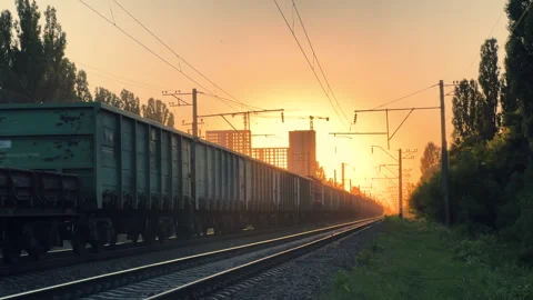 Freight Train Moving Along Railway Tracks at Golden Sunset | Cargo Wagons Stock Footage 340048252