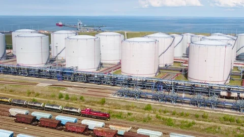 A freight train is moving by the oil refinery on the seashore Video stock 101572943