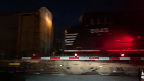 Freight train moving past a gate Stock Footage 173574875