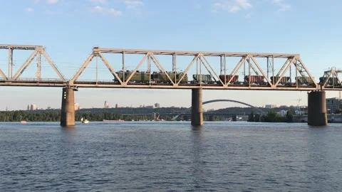 Freight train moving on a railway bridge over a river. Stock Footage 297402842