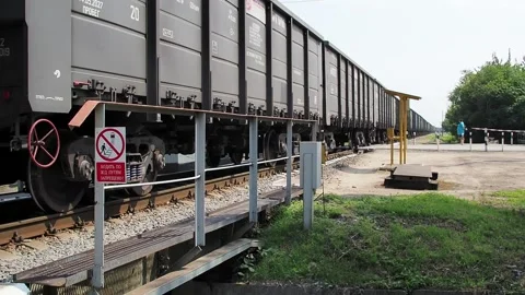 Freight train moving slowly across a small bridge Video stock 136915980