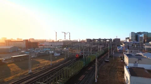 A freight train is moving towards the railway station and the factory at dawn. Stock Footage 165877566