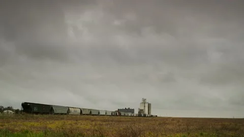 Freight train parked near a grain elevator outside a small town in Nebraska. Video stock 236180819