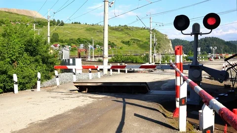 Freight train passes by a closed railway crossing Stock Footage 84626112