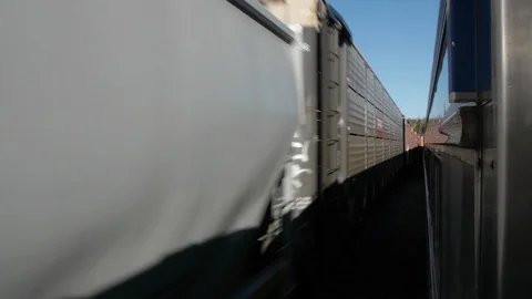 A Freight Train passes the open window of the Passenger Train Stock Footage 92651953