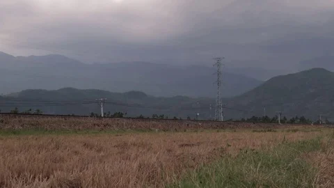 Freight train passes by rice fields in Vietnam overlooking the mountains Vídeo Stock 117435853