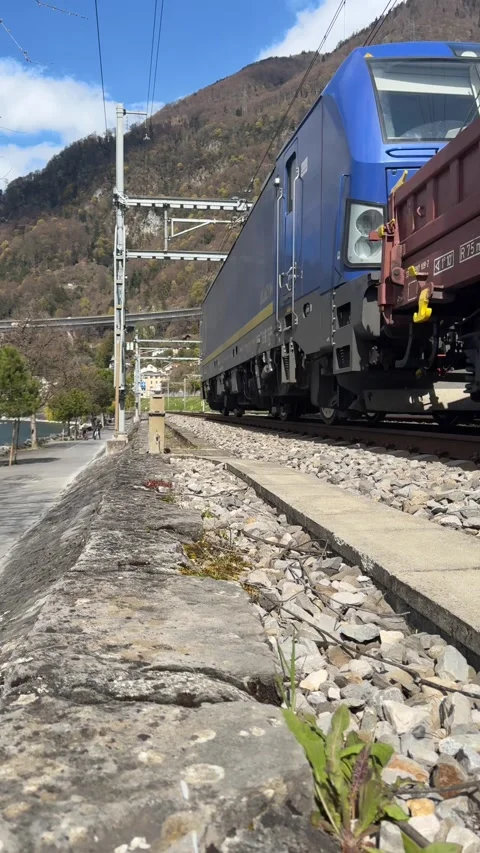 Freight train passing along railway tracks, Villeneuve, Switzerland. Stockbeeldmateriaal 331984965