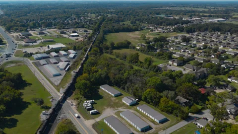 Freight train passing developed outskirts of Gentry, Arkansas 動画素材 345341560