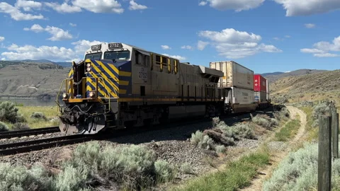 Freight train passing in high desert of B.C. diesel, railway,  4k Vídeo Stock 245308820