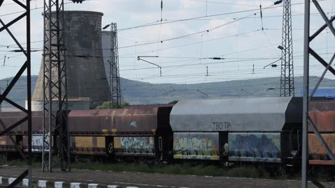 Freight train passing by an industrial power plant Stock Footage 345928299