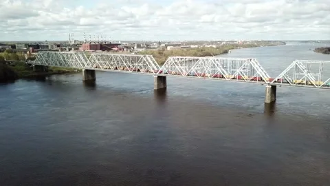 A freight train passing over a bridge over a river Stock Footage 163879820