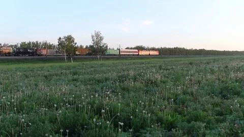 Freight train passing on a railroad track in the field Stock Footage 76912426