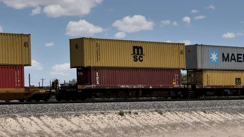 Freight train passing road crossing with locomotives pushing Stock Footage 77742831