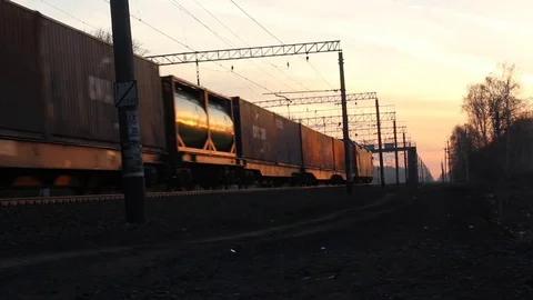 A Freight train is passing by a rural station in sunset light. Stock Footage 74541933