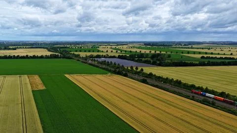 Freight Train Passing Solar Farm Across European Farmland Stock Photos