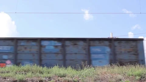 Freight train passing by the station on a sunny summer day close up Stock Footage 138174902