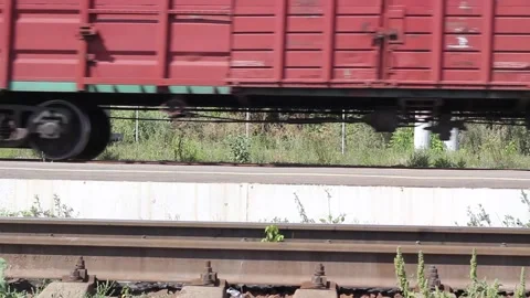 Freight train passing by the station on a sunny summer day close up Video stock 138175092