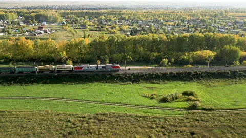 Freight train passing through countryside In the afternoon in autumn day, Aerial Stock Footage 254862426