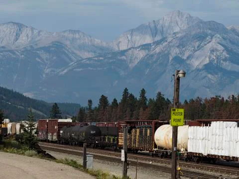 Freight train passing through Jasper, Alberta, Canada. Rocky Mountains in Fotos de archivo