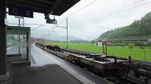 Freight train passing through Schwyz station in Switzerland Stock Footage 334923323