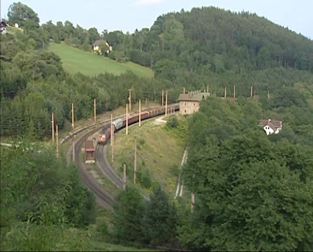 Freight train rides downwards on a mountain slope near Klamm, Austria Stock Footage 33531746