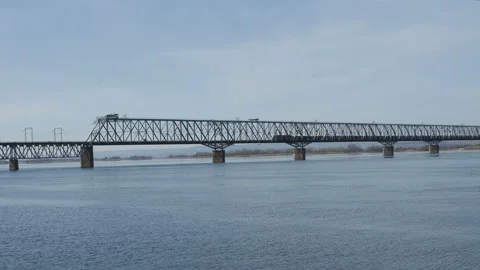 Freight train rides over the bridge.Railway bridge over the river. Sunny spring Vidéo 127498127