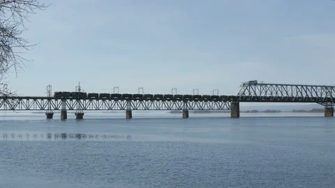 Freight train rides over the bridge.Railway bridge over the river. Sunny spring Видео 127498284