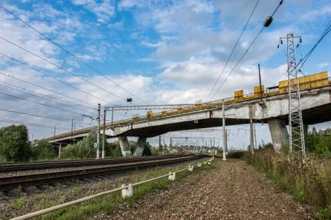 Freight train rides by rail under the road bridge Stock Photos