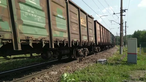Freight train rides on rails in summer. Cargo wagons containers move fast Stock Footage 220337546