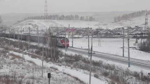 Freight train rides through the village in winter Stock Footage 100030544