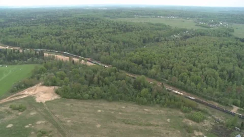 Freight Train rides through the woods, fields and village in Russia Stock Footage 71831826