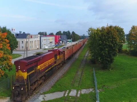 Freight train rolls through scenic rural city at sunrise. Stock Footage 80606191