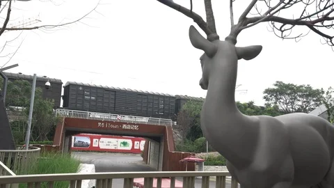 A freight train running past a deer sculpture at an office park in Beijing Stock Footage 93891700