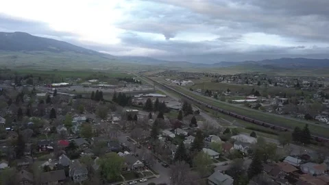 Freight train running through small mountain town Stock Footage 166421842