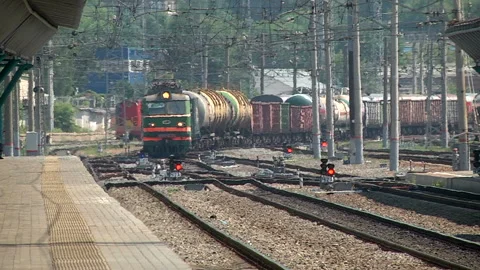 A freight train runs along the platform of the station Stock Footage 98114075