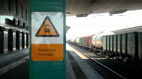 A freight train runs along the platform of the station Stock Footage 98123906