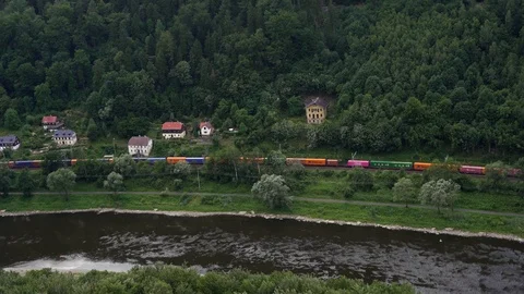 Freight train seen traveling through a forested valley moving along the coastlin Stock Footage 126908721