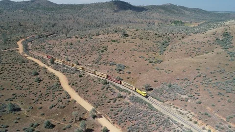 Freight Train Snakes through Rolling Foothills in Northern California Stock Footage 89825806