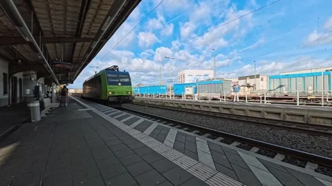 Freight train transporting cargo trucks passing through railway station Stock Footage 320161328