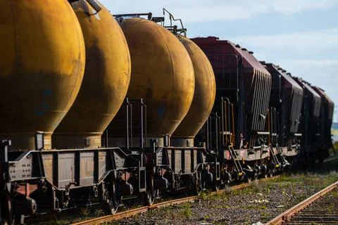 Freight train transporting tanks through an industrial area Stock-Fotos