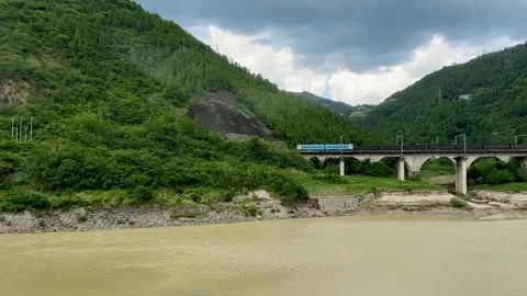 Freight train traveling between mountains at Mingyue Gorge in Guangyuan Stock Footage 316283719