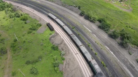 Freight train turning on railway in green landscape, aerial drone view Stock Footage 313018991