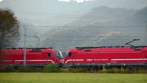 Freight train with two red locomotives traveling Stock Footage 169916564