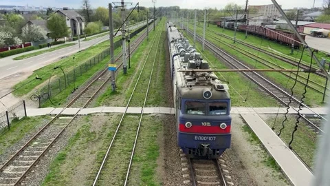 A freight train with wagons is moving along the track. Ukrainian railway Stock Footage 239450075